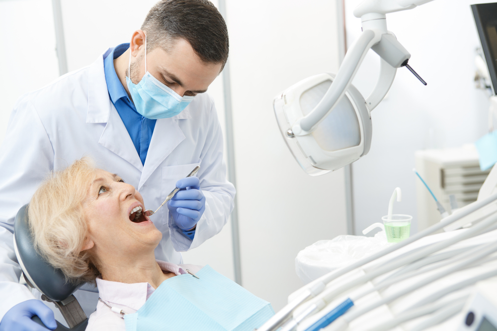 stock-photo-mature-male-dentist-working-with-his-elderly-patient-senior-woman-visiting-dentist-having-dental-631495172
